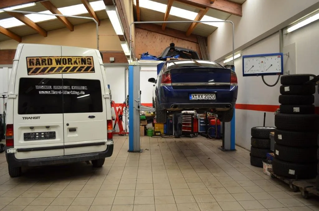 Werkstatthalle von RM Autoservice Perisic mit zwei Hebebühnen, einem angehobenen Pkw und eingelagerten Reifensätzen